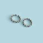 Flat lay image of Infinity Link Oxidized Toe Rings on solid background