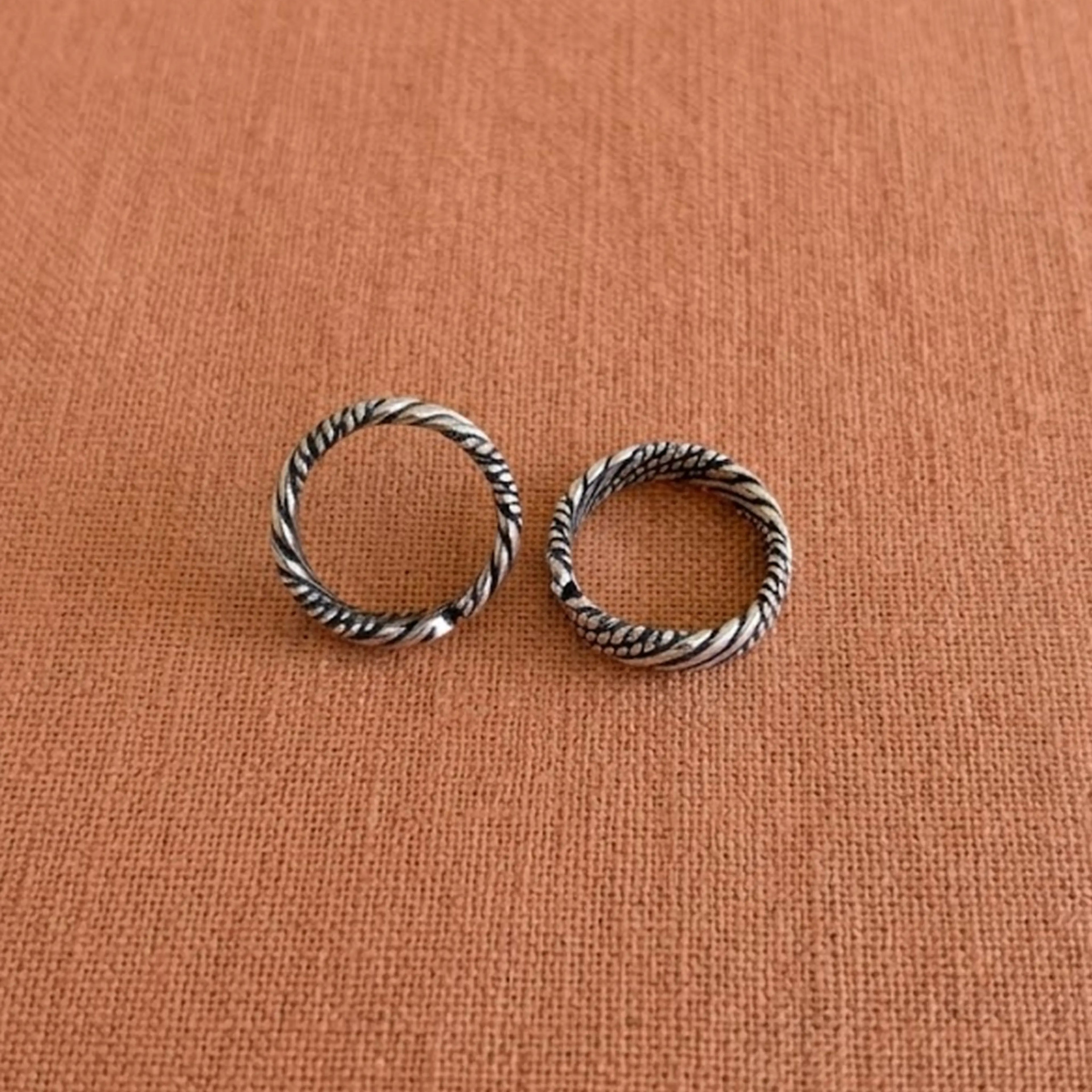 Multi-Textured Oxidized Twist Toe Rings on solid background
