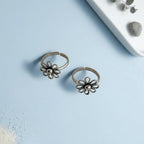 Wire Flower petal toe ring on solid background