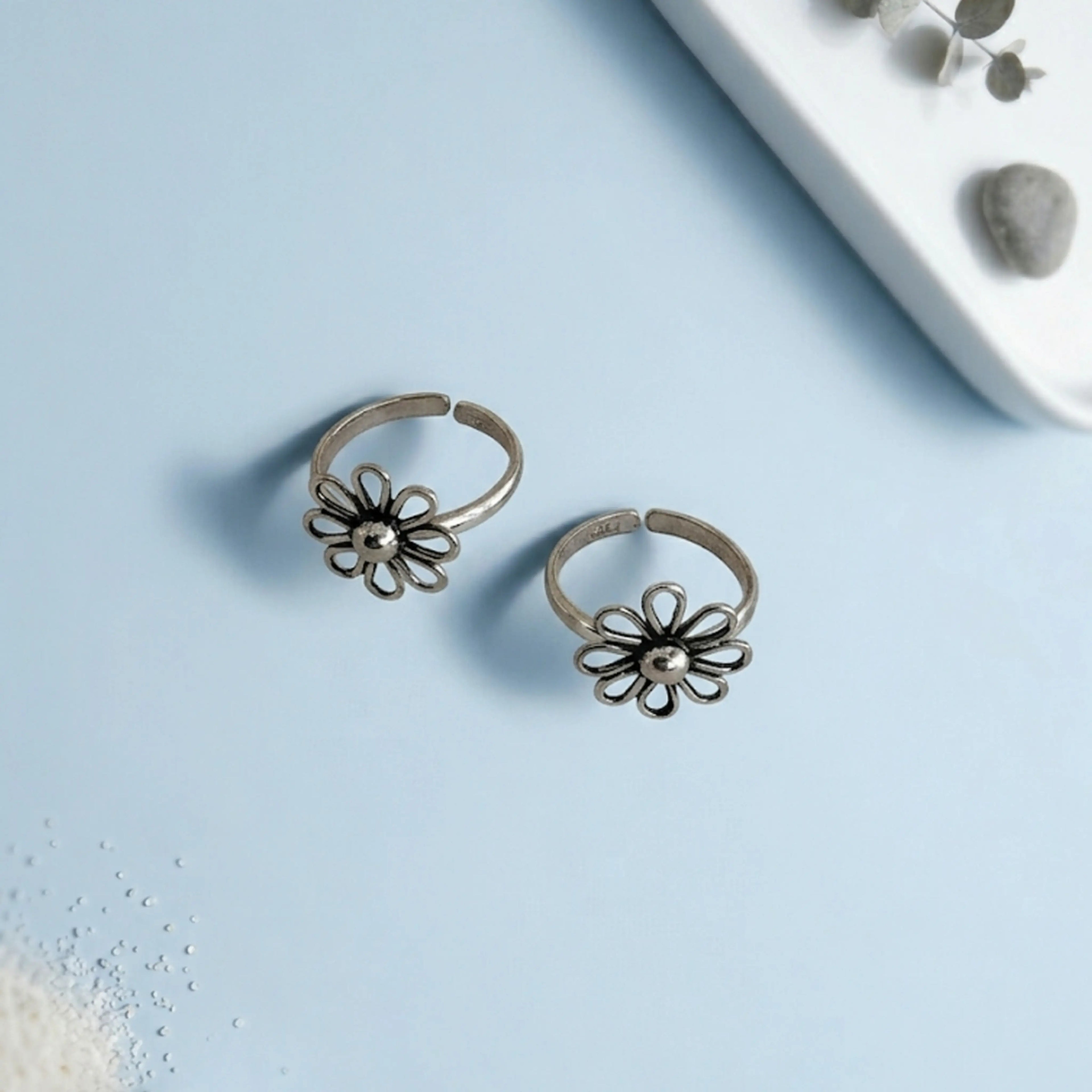 Wire Flower petal toe ring on solid background