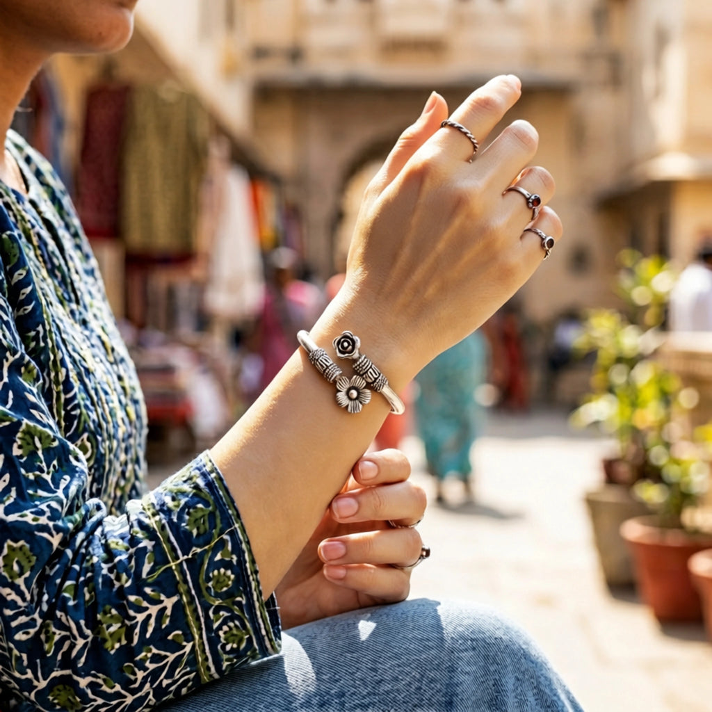 Person wearing multiple rings and a bracelet on a blurred street background