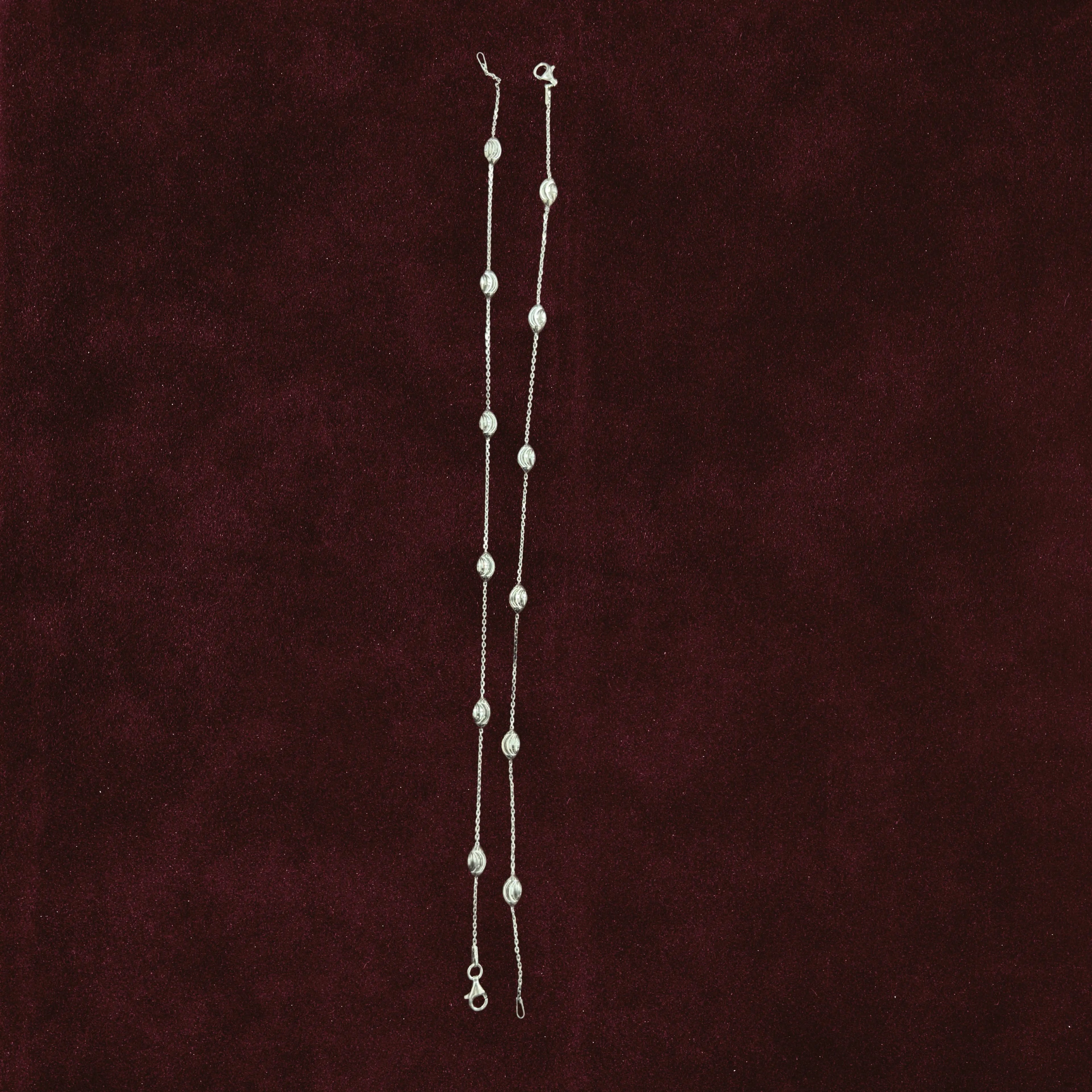 Sculpted Oval Link Anklet Pair on a maroon background