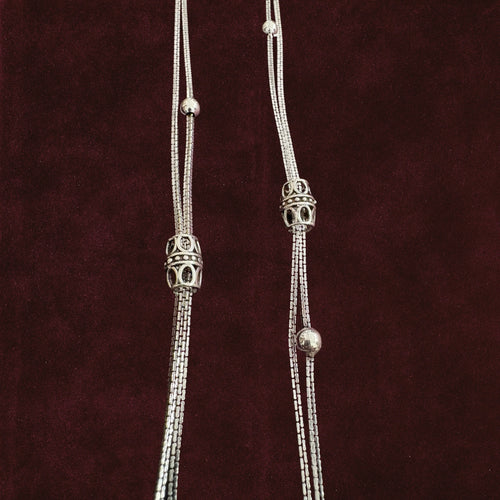 Closeup of Double-Strand Filigree Orbit Anklet Pair on a maroon background