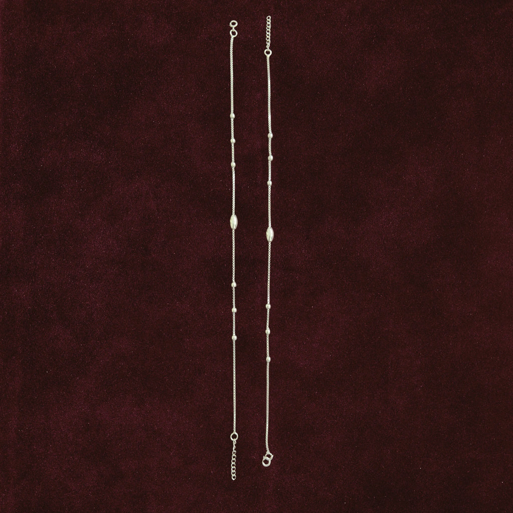 Celestial Orbit Anklet Pair on a maroon background