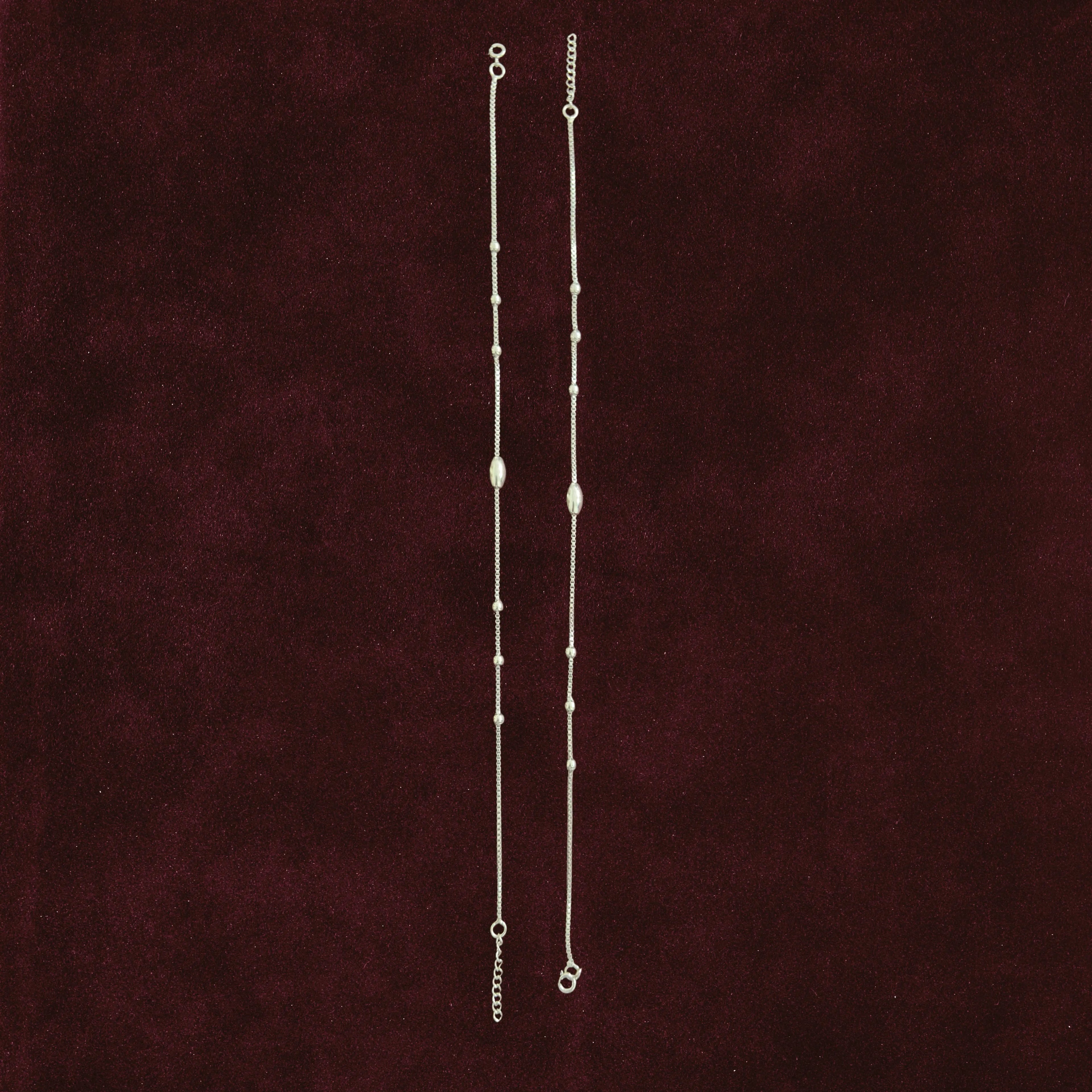Celestial Orbit Anklet Pair on a maroon background