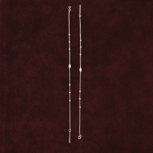 Celestial Orbit Anklet Pair on a maroon background