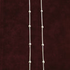 Silver dew drop anklet pair closeup on solid background