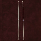 Sapphire Evil Eye Anklet Pair on a maroon background
