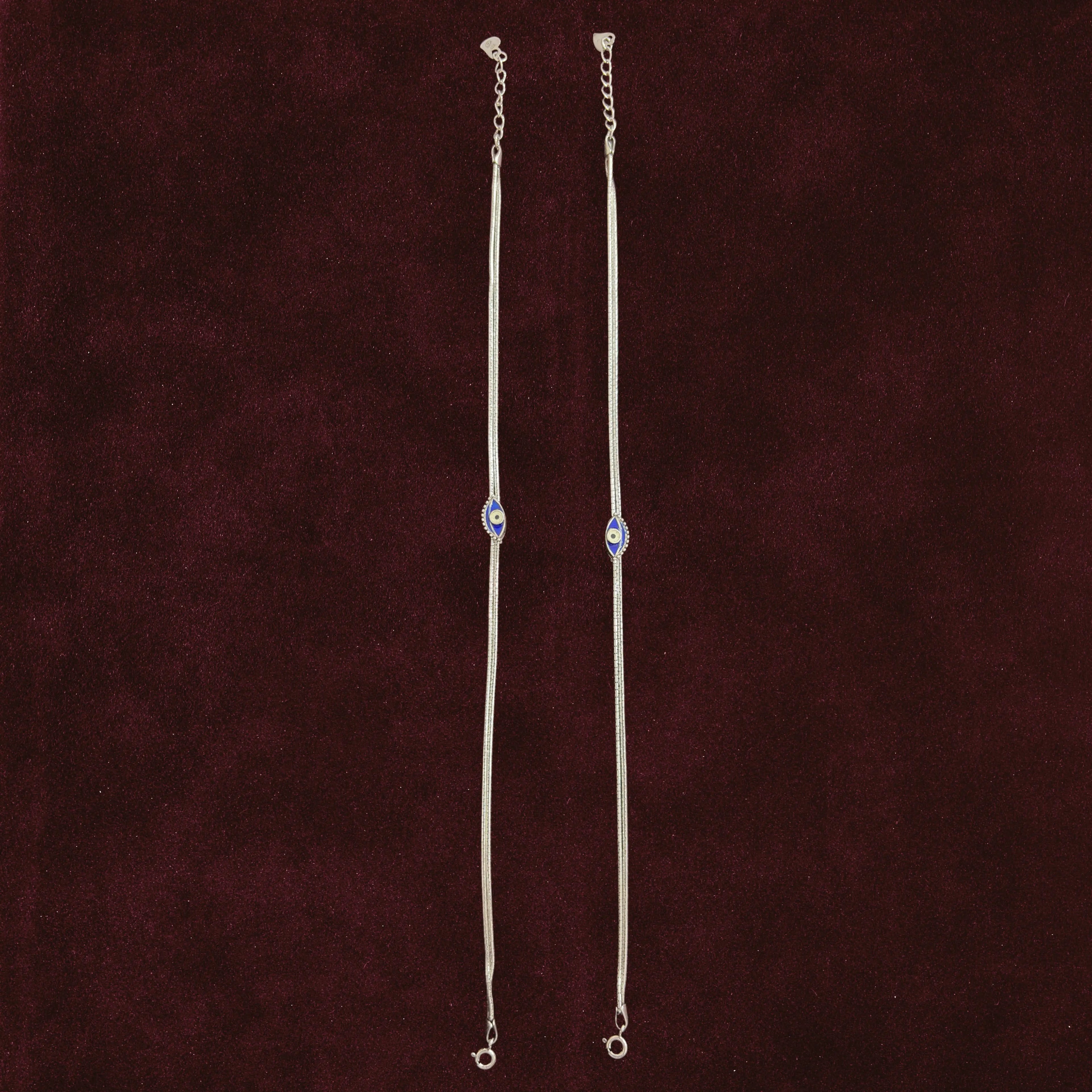 Sapphire Evil Eye Anklet Pair on a maroon background