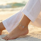 Neelima Glimmer Evil Eye Anklet closeup image of Indian woman sitting on beach