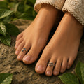 Feet with silver rings on toes against a natural background
