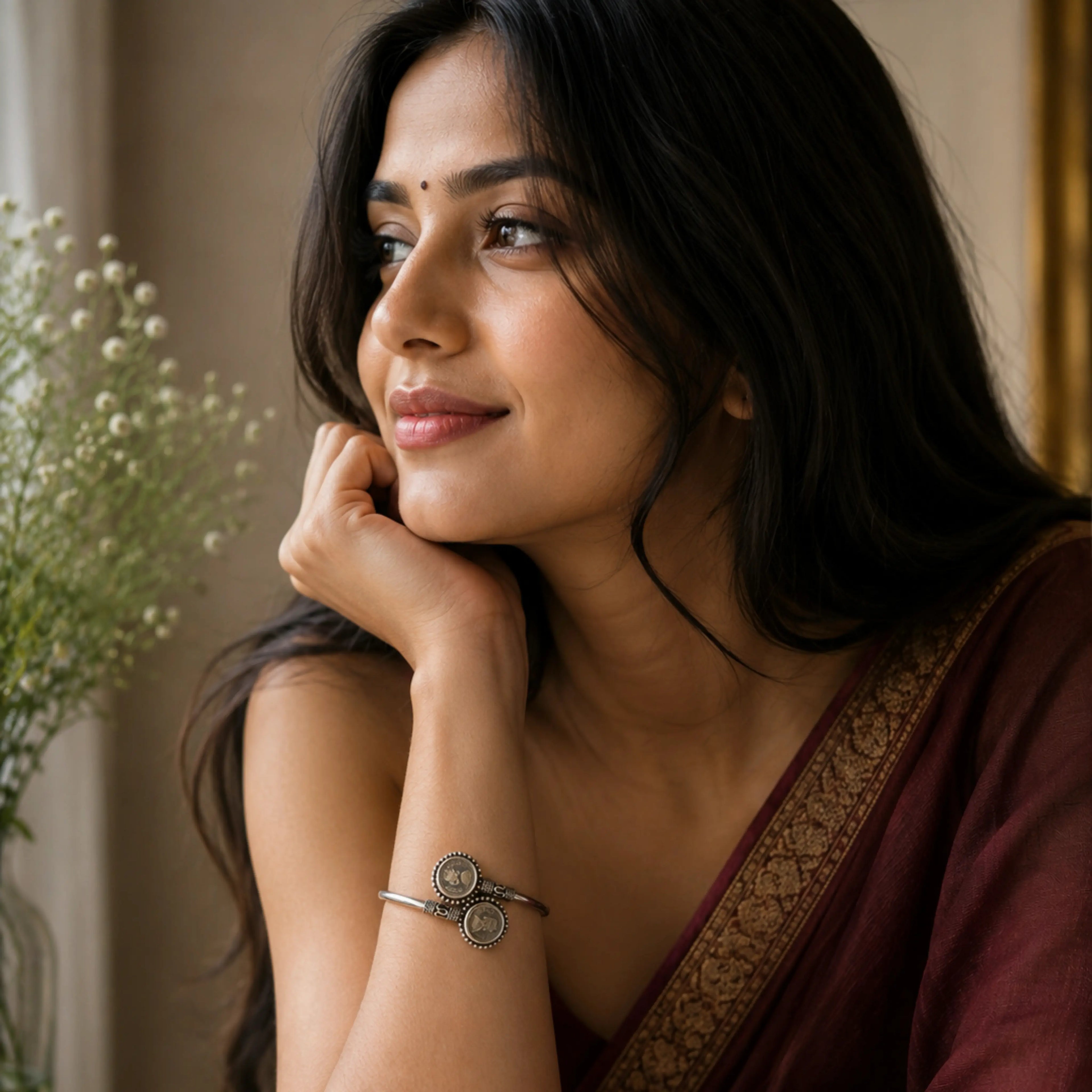 Woman wearing a maroon saree with a Victoria bracelet in subtle background