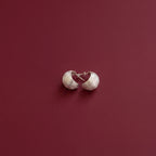 Pair of 925 silver earrings on a red background