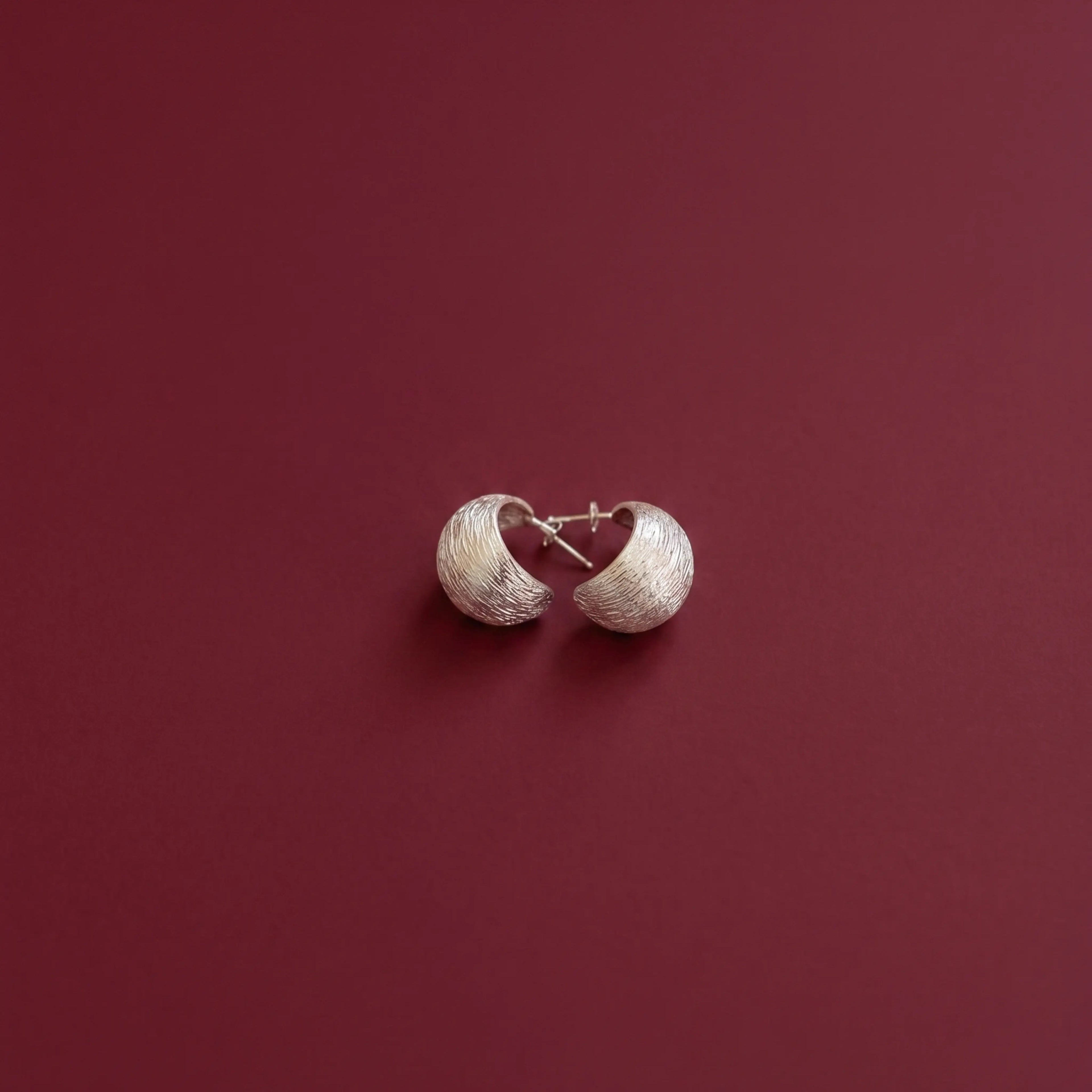 Pair of 925 silver earrings on a red background