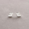 Silver elephant-shaped earrings on a light gray background