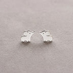 Silver elephant-shaped earrings on a light gray background