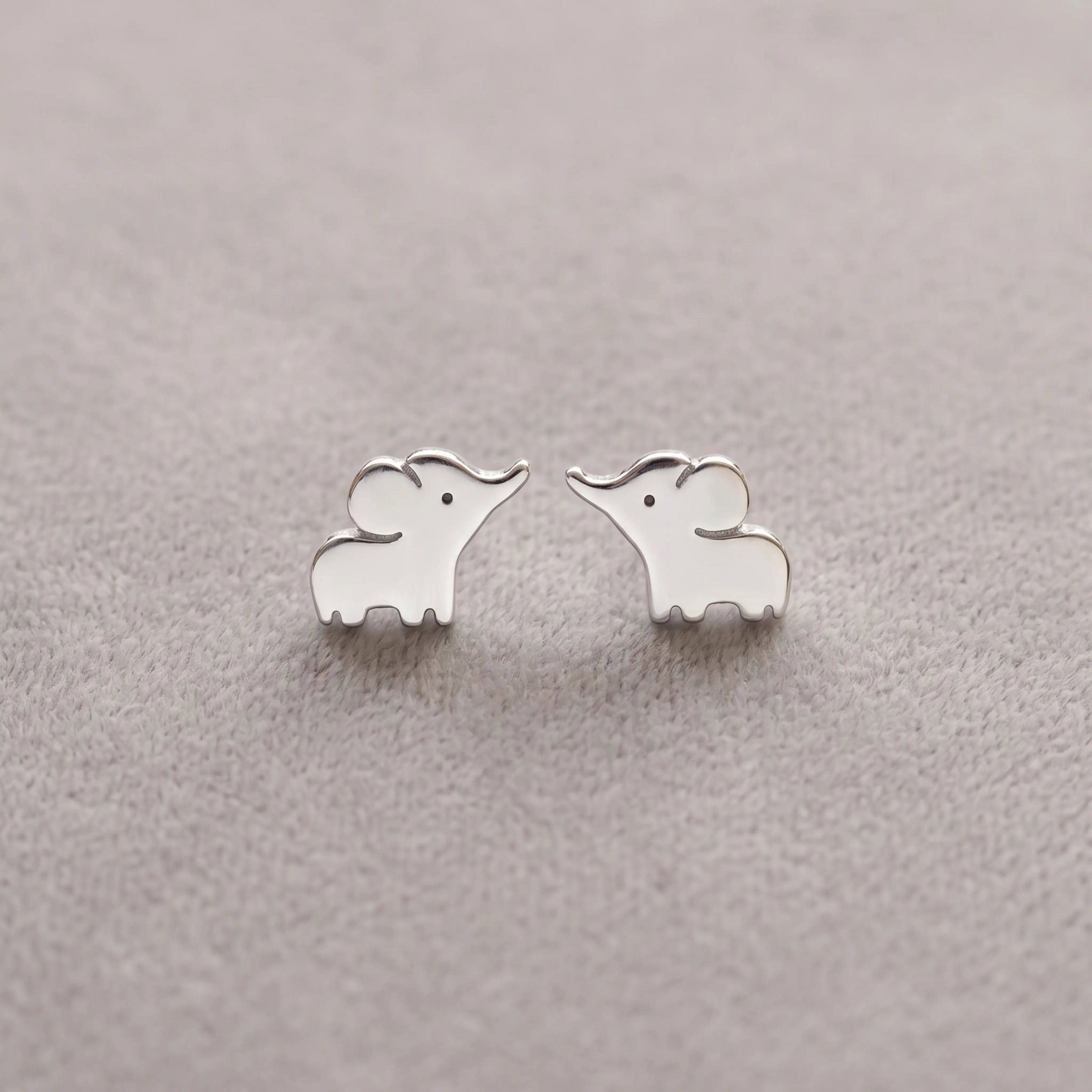 Silver elephant-shaped earrings on a light gray background