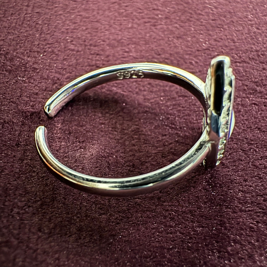 Silver toe ring with '925' stamp on a maroon surface