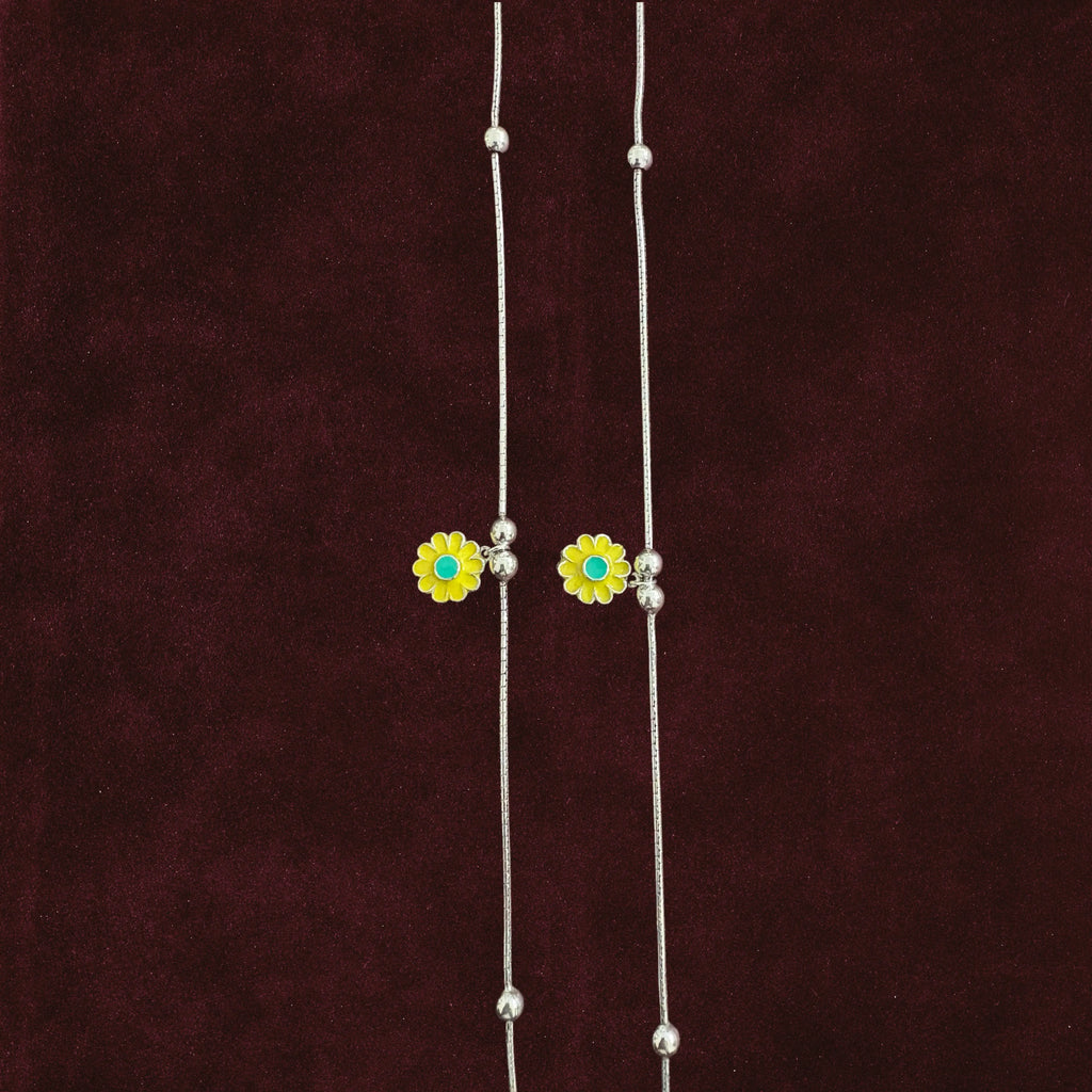 Close up of Sunflower Snake Chain Anklet Pair on maroon background