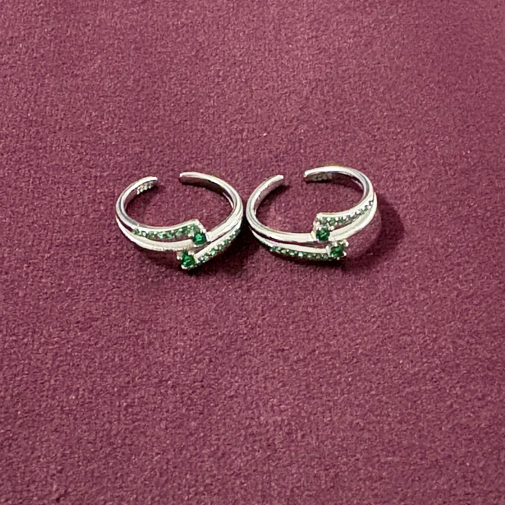 Dual Arch Emerald Toe Rings on maroon background
