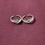 Dual Arch Emerald Toe Rings on maroon background