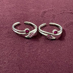 Flatly image of Ruby Rosebud Dual Arch Toe Rings on maroon background