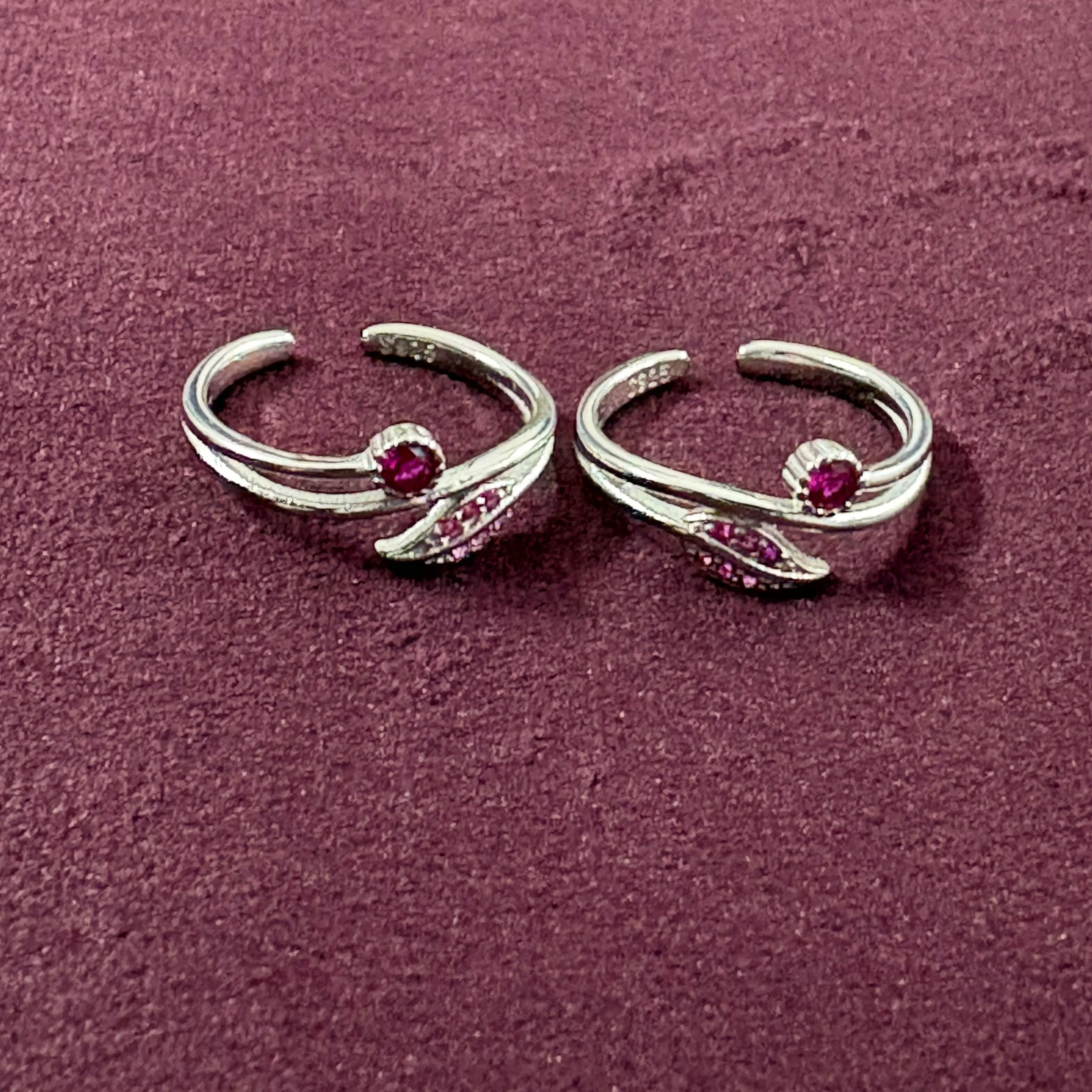 Flatly image of Ruby Rosebud Dual Arch Toe Rings on maroon background