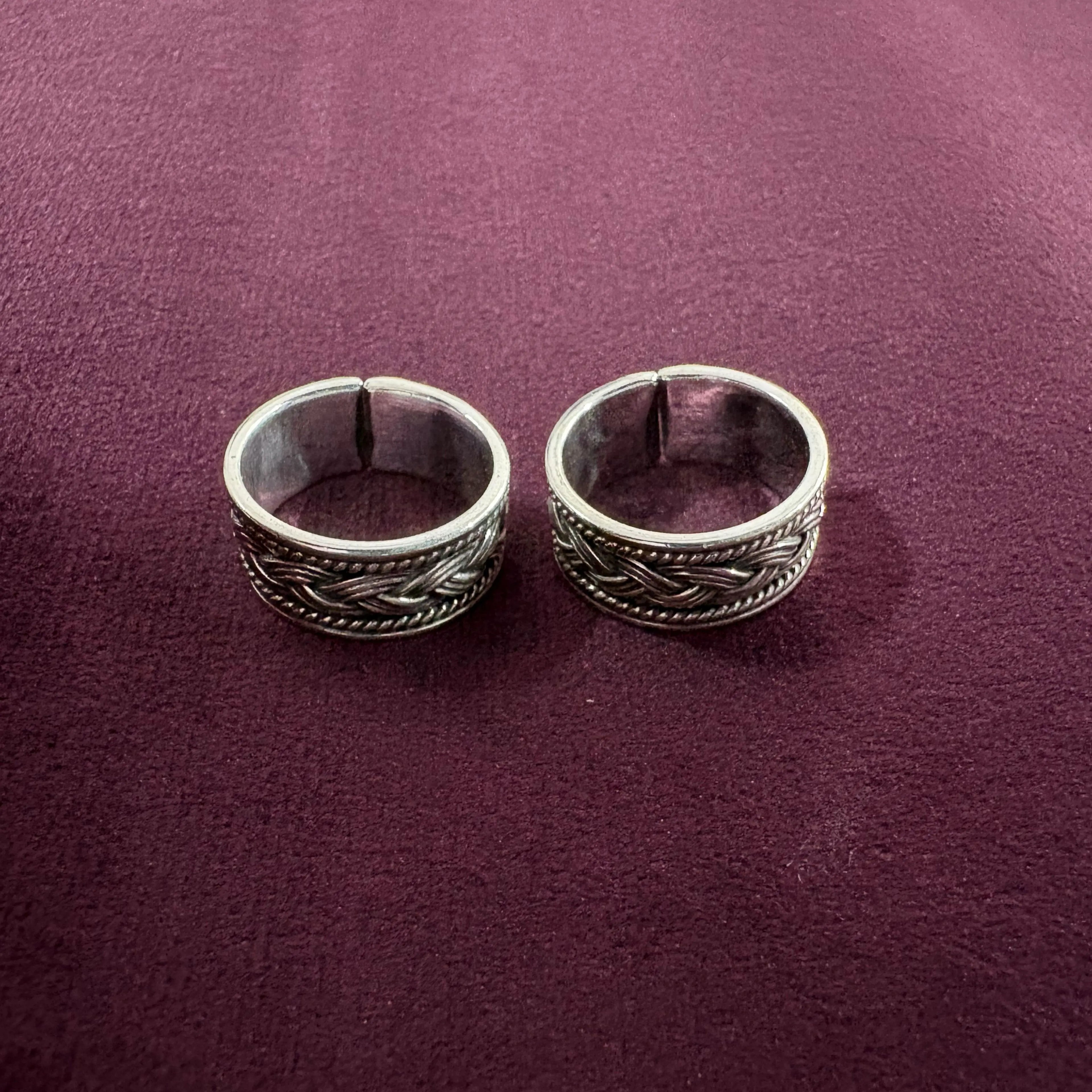 Oxidized Celtic Braid Toe Ring pair on maroon background