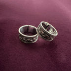 Oxidized Celtic Braid Toe Rings on maroon background