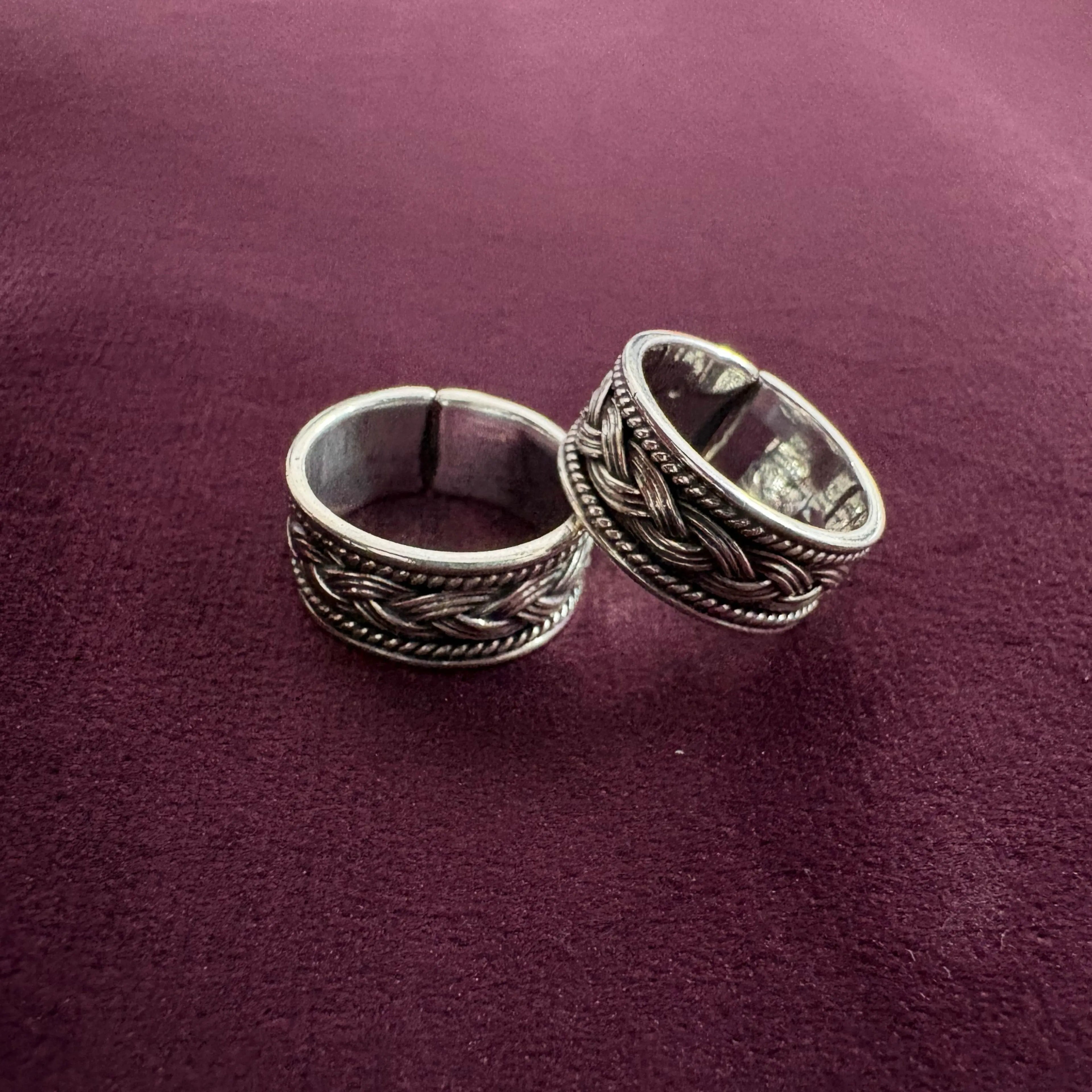 Oxidized Celtic Braid Toe Rings on maroon background