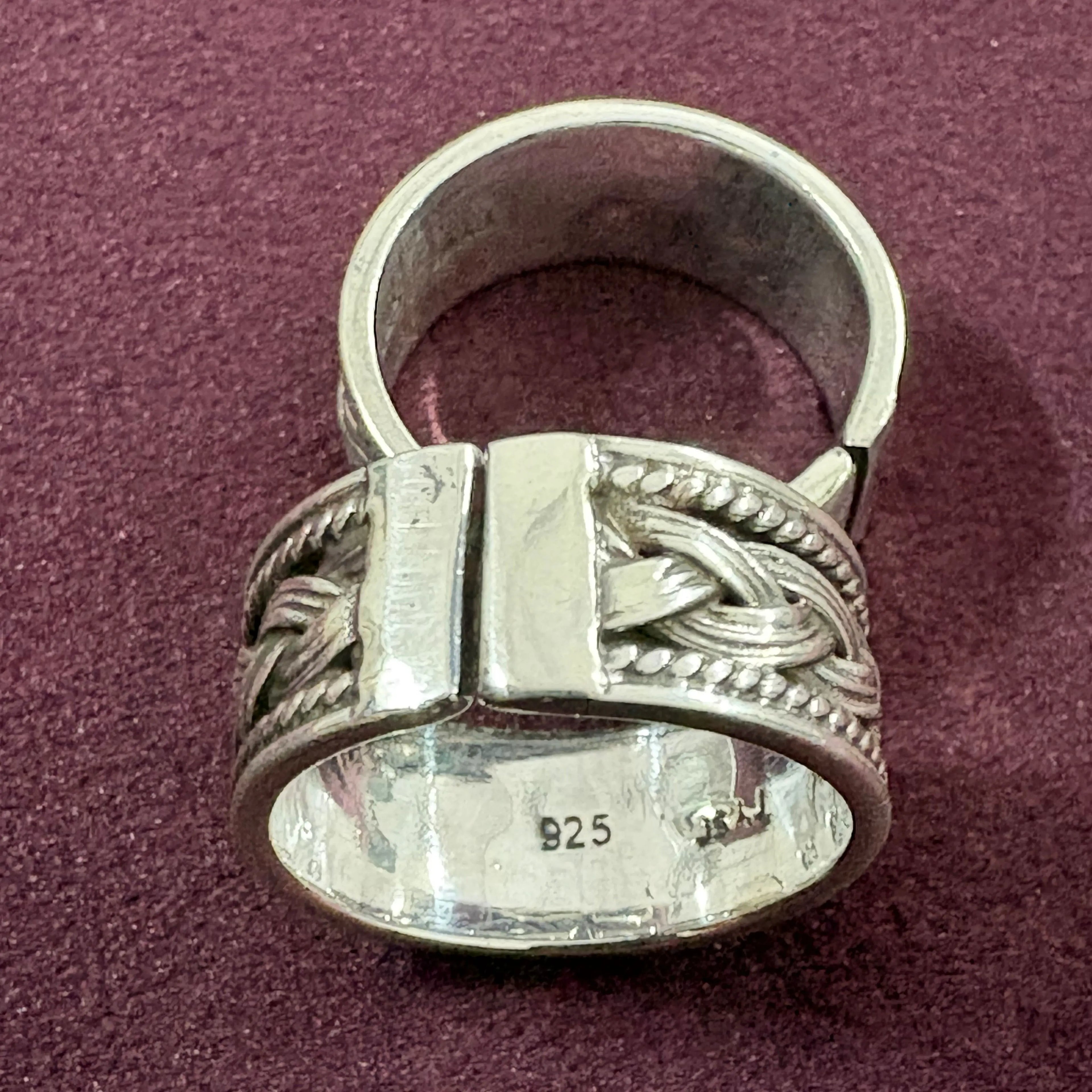 Flat lay image of Oxidized Celtic Braid Toe Ring pair on maroon background
