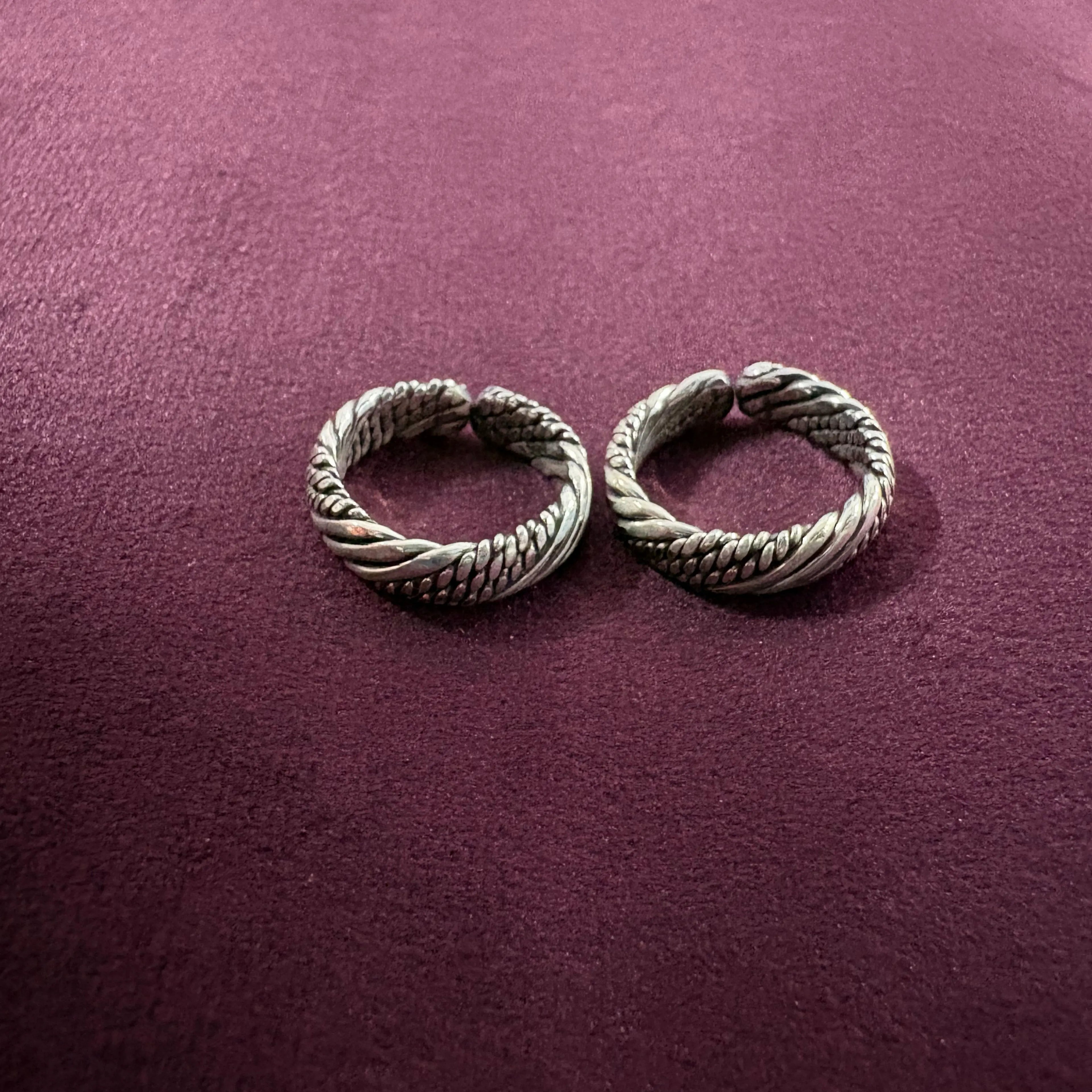 Multi-Textured Oxidized Twist Toe Rings on maroon background