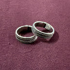 Flat lay image of Classic Rope Band Toe Rings on maroon background
