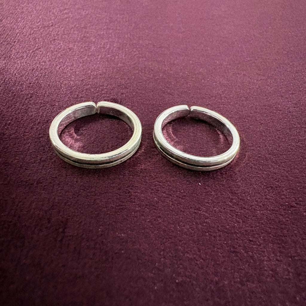 Sleek Grooved Band Toe Rings on maroon background