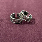 Flat lay image of Garden Jaali Oxidized Toe Rings on maroon background