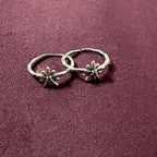 Flat lay image of Starry Flora Oxidised Toe Rings on maroon background