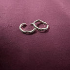 Flat lay image of Wavy Beaded Oxidized Band Toe Rings on maroon background