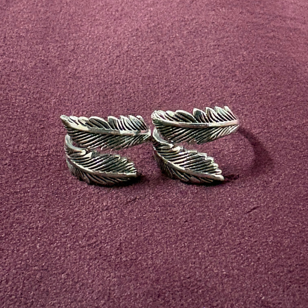 Double Feather Oxidized Bypass Toe Rings on maroon background