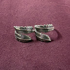 Double Feather Oxidized Bypass Toe Rings on maroon background