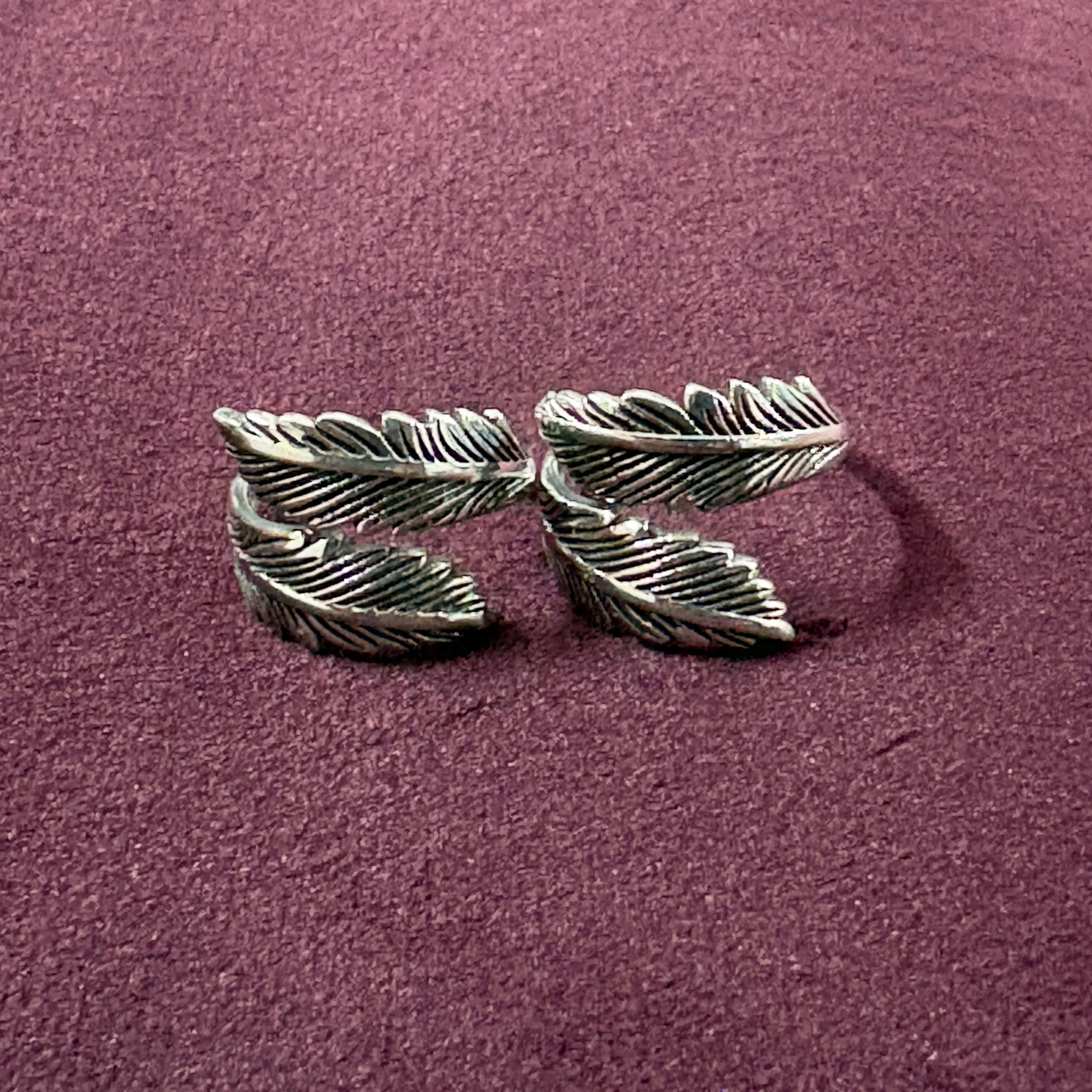 Double Feather Oxidized Bypass Toe Rings on maroon background