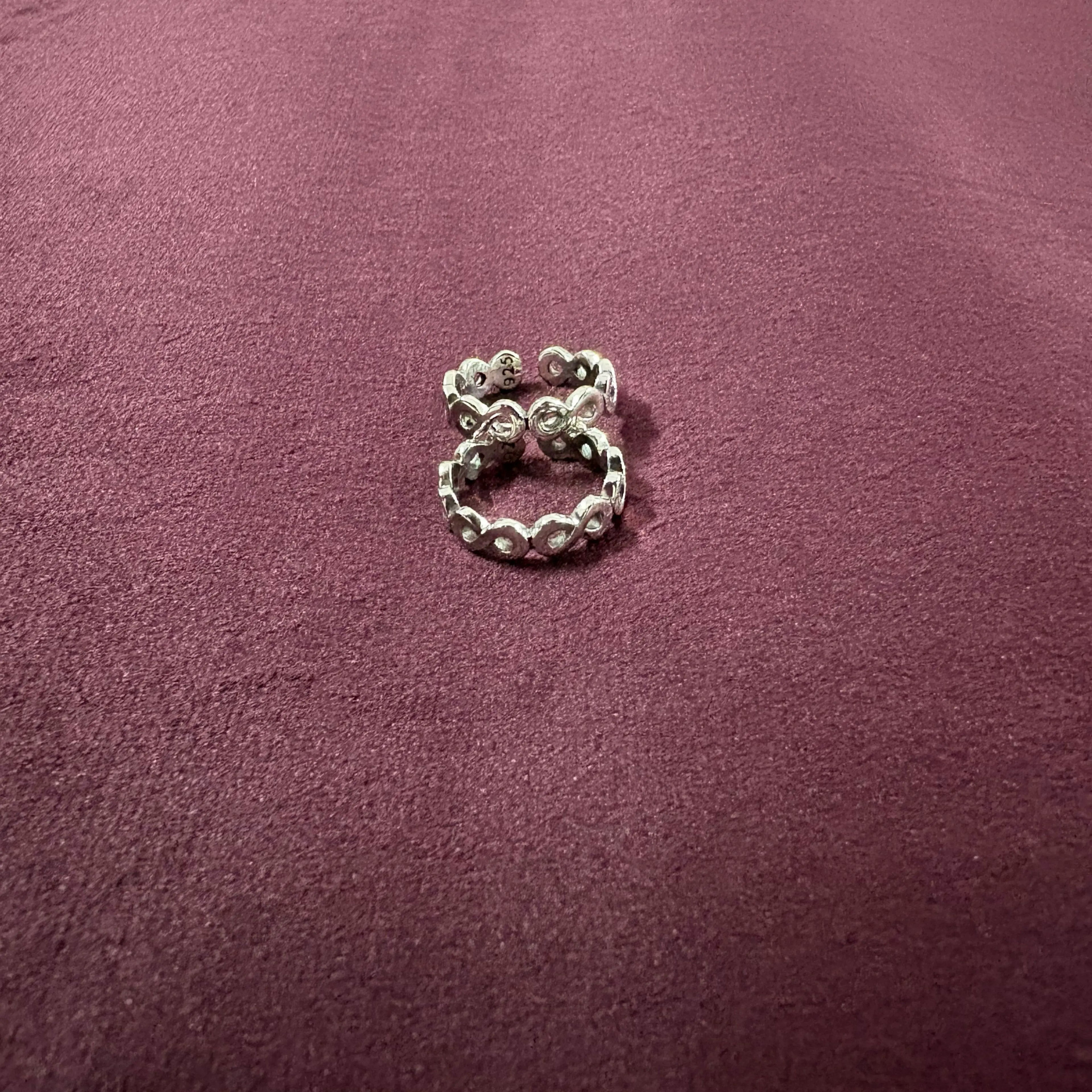 Infinity Link Oxidized Toe Rings on maroon background