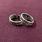 Flat lay image of Intricate Filigree Oxidized Toe Rings on maroon background
