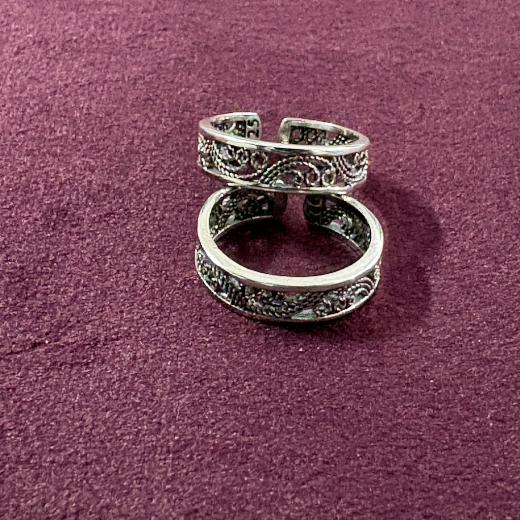 Intricate Filigree Oxidized Toe Rings on maroon background