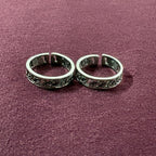 Ivy Leaf toe ring pair on maroon background