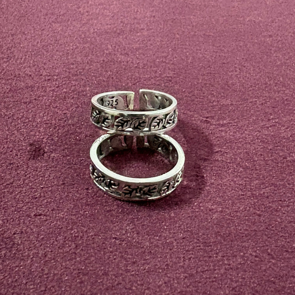 Flat lay image of Ivy Leaf toe ring pair on maroon background