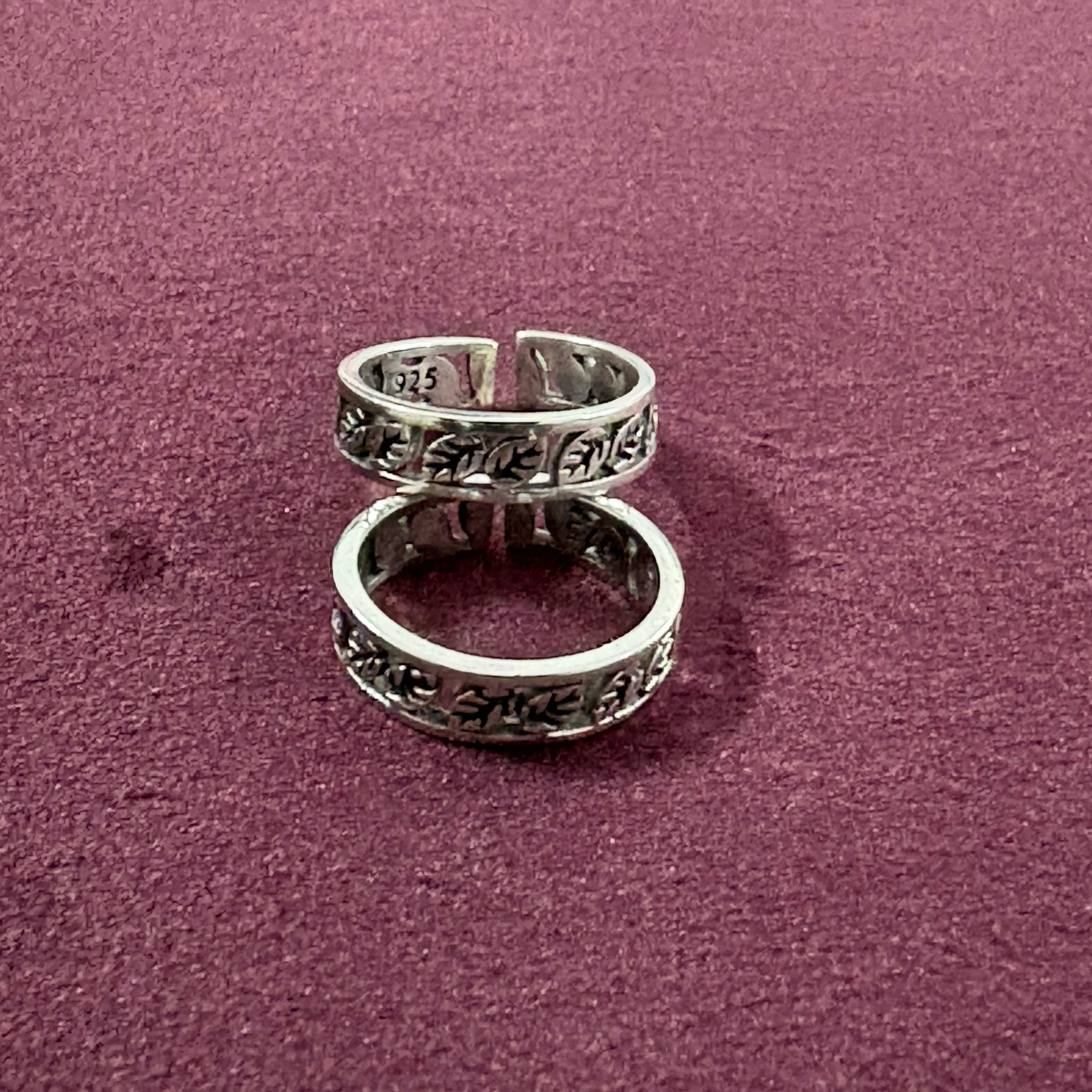 Flat lay image of Ivy Leaf toe ring pair on maroon background