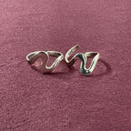 Ebb & flow toe ring pair on maroon backgroun