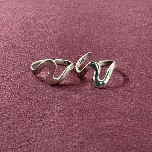 Ebb & flow toe ring pair on maroon backgroun