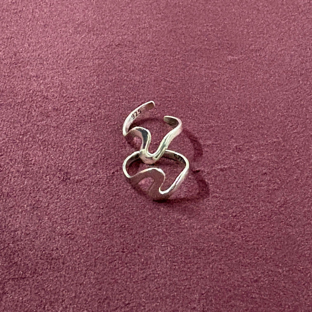 Flatly image of Ebb & flow toe ring pair on maroon backgroun