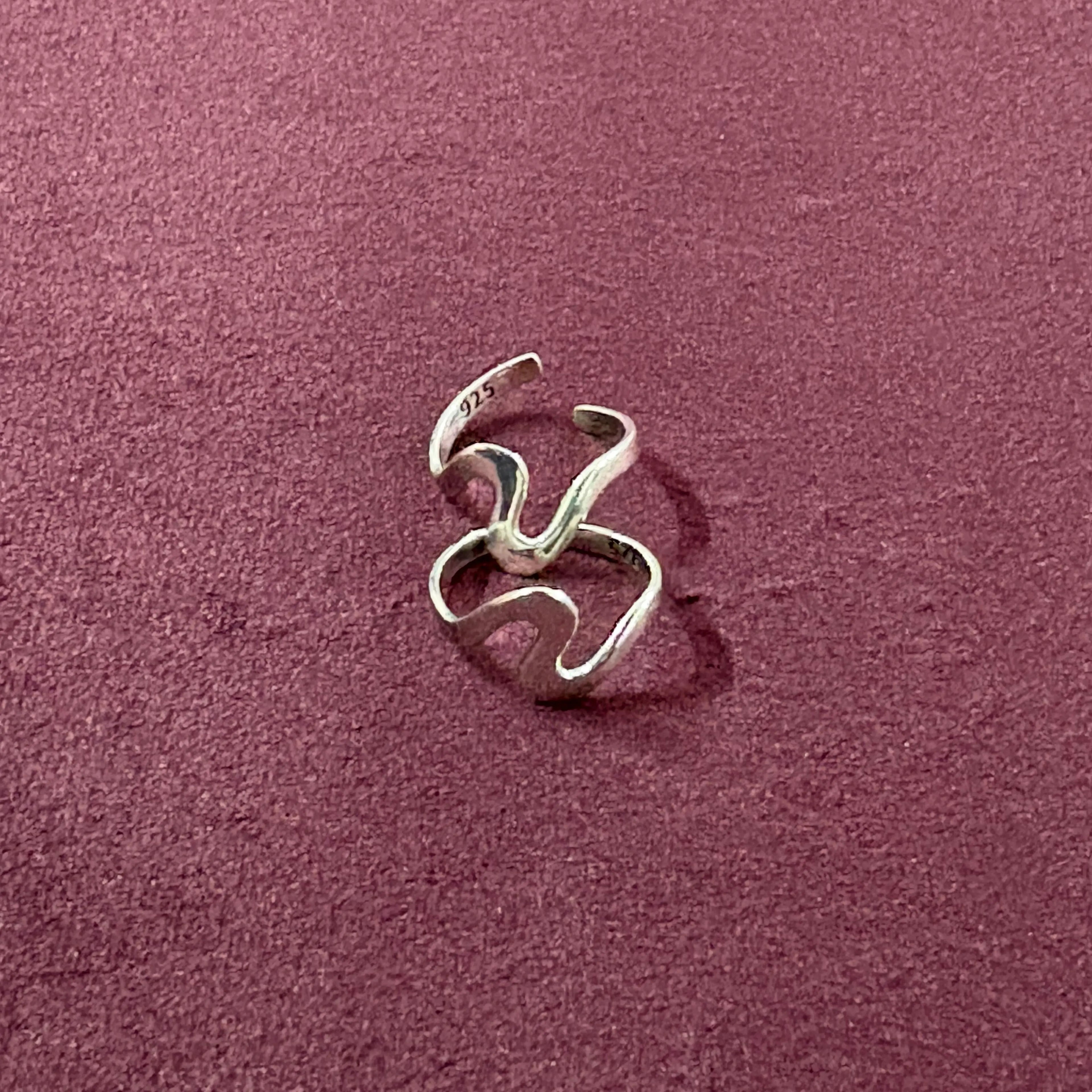 Flatly image of Ebb & flow toe ring pair on maroon backgroun